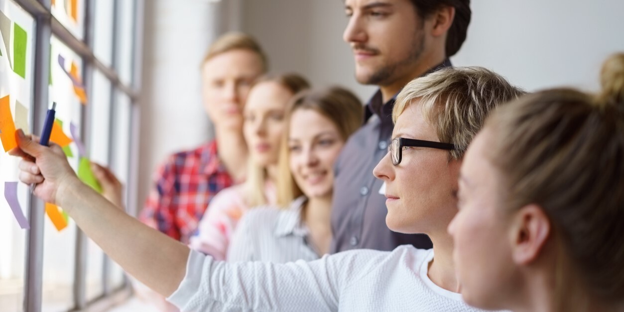 Arbeitskollegen diskutieren Ideen mit Haftnotizen